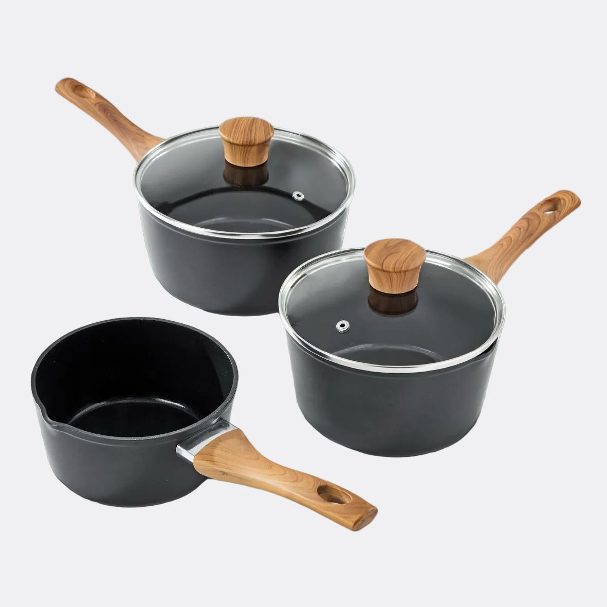 Set of three black cookware pots with wooden handles on a grey background