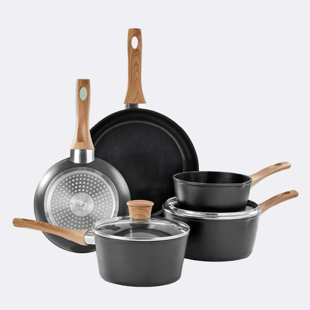 Set of black cookware with wooden handles on a grey background